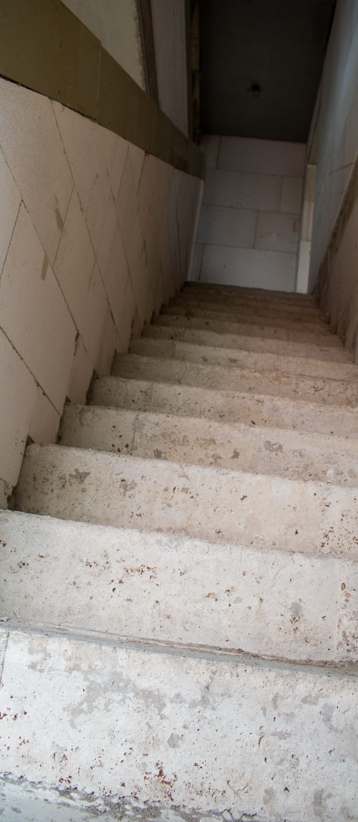 Betontreppe, die nach oben führt, mit weißen Wänden auf beiden Seiten.